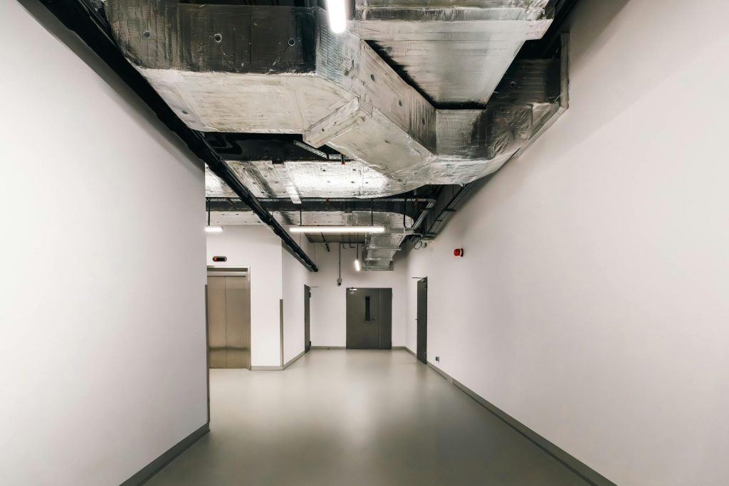 Spacious industrial hallway featuring exposed HVAC ductwork and modern design elements.